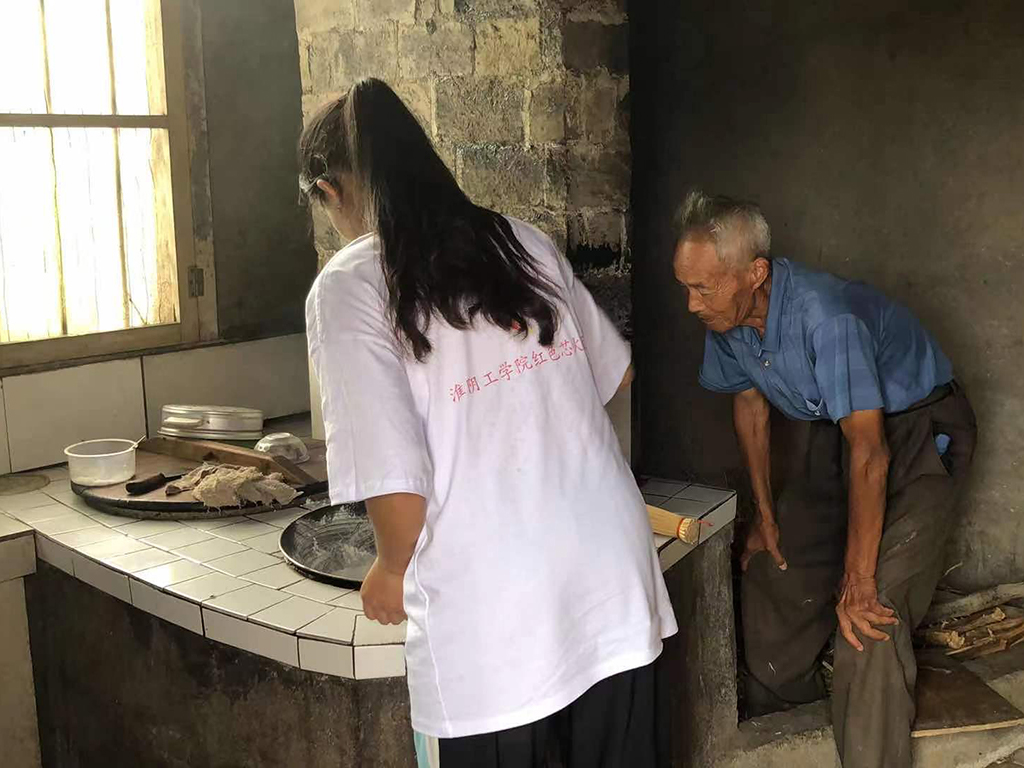 学生党员与抗美援朝英雄爷爷一起制作红色饮食“炒面”