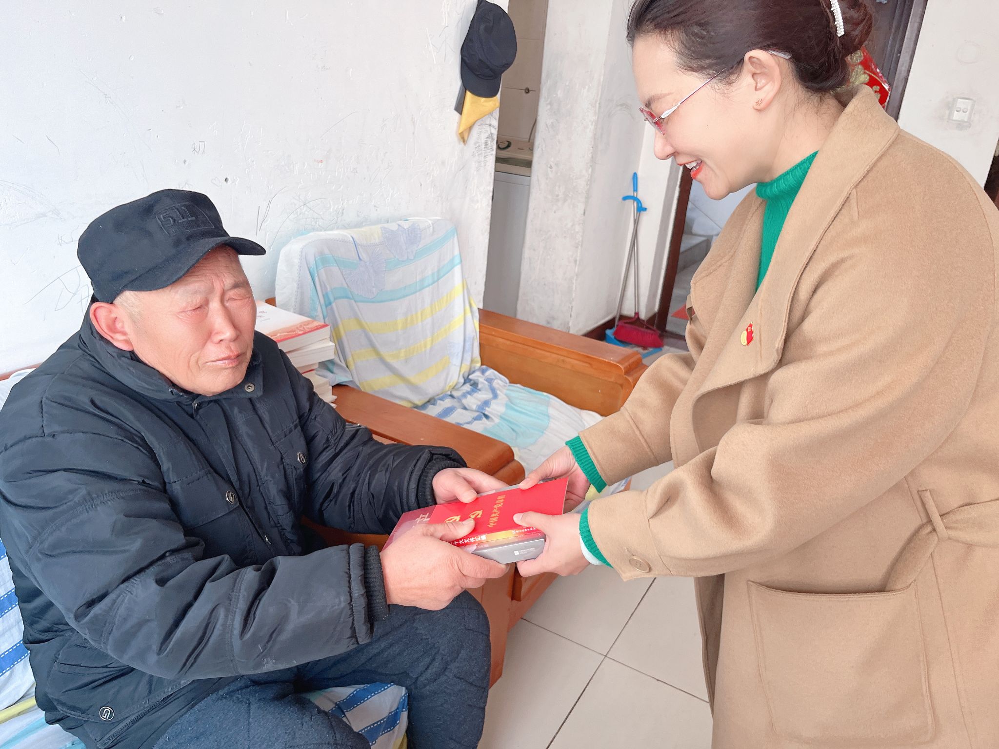 向老党员赠送《党章》等学习资料